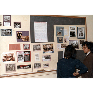 Guests and bulletin board at an International Workers' Day event