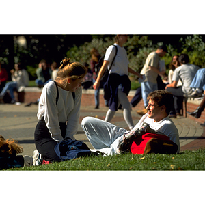 Students sit on grass near Snell Library