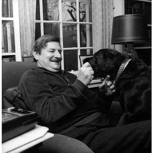 Rudolph Morris poses in his home library with his dog