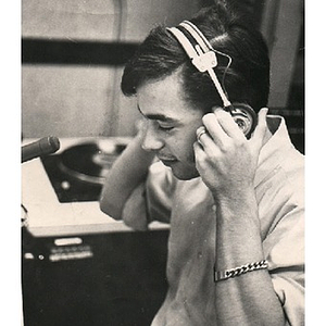 Young man adjusting headphones in the broadcast booth at the WNEU studio