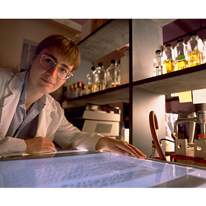 A young woman examining a transparency in a laboratory as part of her co-op