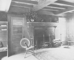 Interior view with fireplace and spinning wheel, Manchester, Mass., undated