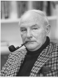 Thomas M. McAuley sitting indoors, with pipe