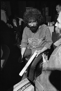 Grateful Dead performing at the Music Hall: Jerry Garcia backstage holding a rolled-up poster and cigarette
