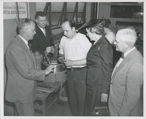 Mary Switzer and a group of men observe a trainee at the Institute for the Crippled and Disabled