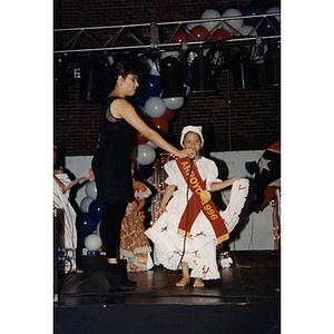 A woman holds a microphone up for a young girl wearing an Arroyo 1996 sash during the Puerto Rican Festival