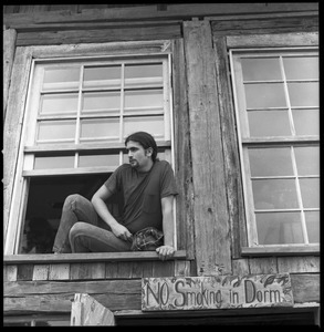 Commune member leaning out an upstairs window of the Brotherhood of the Spirit communal dormitory