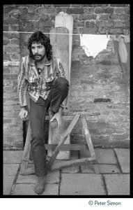 Cat Stevens: full-length portrait, seated by a laundry line on Carly Simon's back door patio