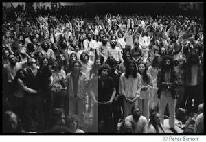 Audience in the Winterland Ballroom raising their arms in ecstasy, listening to Amazing Grace during the Ram Dass 'marathon'