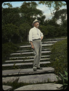 Jens Jensen (man standing on wide steps with plants around)