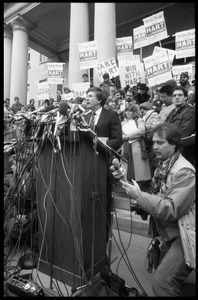 Gary Hart at a microphone-encrusted podium, addressing an crowd after renewing his bid for the Democratic nomination for the presidency