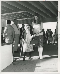 Woman with cane assisted on ship