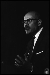 Isaac Deutscher, speaking at the National Teach-in on the Vietnam War: half-length portrait, standing at the podium