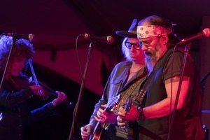 Steve Earle (guitar), Chris Masterson (guitar), and Eleanor Whitmore (fiddle) performing onstage with Steve Earle and the Dukes at the Payomet Performing Arts Center