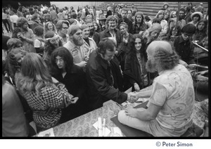 Ram Dass seated on stage at the College of Marin, talking to audience members