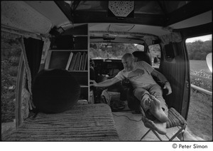 Ram Dass in his van: Ram Dass seated with his feet up