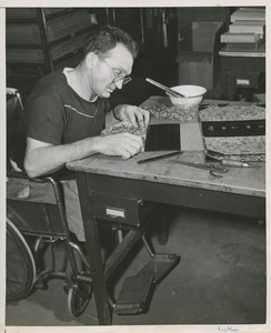 Man in wheelchair making book covers