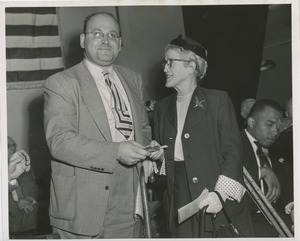 Unidentified man using a cane handing a gift to a client at an ICD event