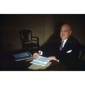 President Ell seated at desk