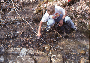 Rebecca Parkinson (Class of 2000) examines water valve in Ford Glen Brook, infrastructure for the Buxton Farms - AL Hopkins' mansion domestic water system.