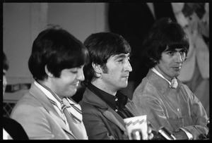Paul McCartney, John Lennon, and George Harrison (l. to r.) seated at a table during a Beatles press conference