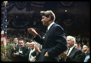 Robert F. Kennedy on the campaign trail, walking into a packed auditorium, while stumping for Democratic candidates in the northern Midwest