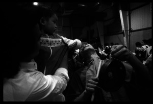 Cambodian New Year's celebration: infant placing money between the teeth of a drummer