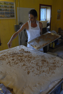 Hungry Ghost Bread: owner and baker Jonathan C. Stevens spreading filling dough for cinnamon rolls