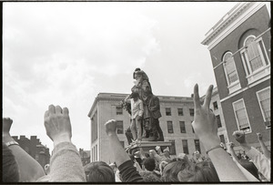 Demonstration at State House against the killings at Kent State: cheering protesters by Horace Mann statue, flashing peace sign