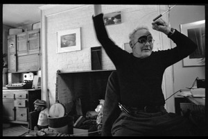 W. Eugene Smith, seated at a desk in his home