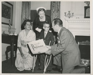 Mayor Robert F. Wagner presenting a proclamation from the American theatre wing to a young boy with forearm crutches