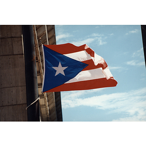 A Puerto Rican flag flying next to a building