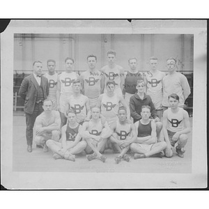 Group portrait of track team and coaches inside gym