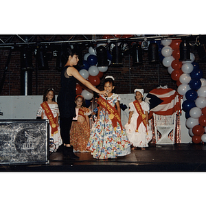 A little girl speaks into a microphone being held for her at the Festival Puertorriqueño