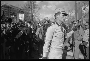 American Nazi Party counter-protester Douglas L. Niles, in uniform, walking away from news media: sign in background reads 'Beatniks, Vietniks, sedition mongers, and all other assorted traitorous cowardly scum, drop dead twice': Washington Vietnam March for Peace