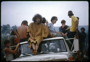 Concert-goers seated on top of a pickup truck during the Woodstock Festival