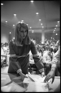 Young woman distributing tests at the Selective Service College Qualification examination to determine eligibility for an educational deferment from service in the Vietnam War