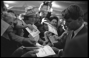 Robert F. Kennedy signing autographs for the crowd after speaking at a dinner while stumping for Democratic candidates in the northern Midwest
