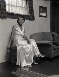 Mrs. Carl Miller (?) posed, seated next to a couch