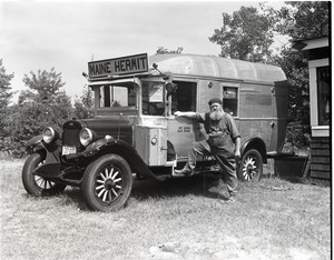 Charles Coffin, The Maine Hermit, posed with his bus with sign "Maine Hermit"
