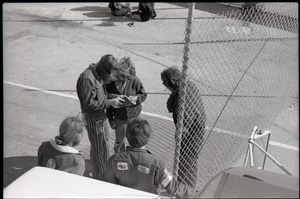 Hollywood Speedway Rock Festival: Free Spirit Press crew talking by chain link fence