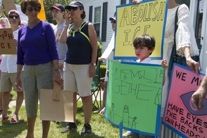 Young boy carrying a sign reading 'Keep families together' at a pro-immigration rally in front of the Chatham town offices building : taken at the 'Families Belong Together' protest against the Trump administration's immigration policies