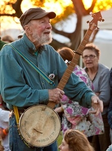 Pete Seeger walking with his banjo at sunset during the Clearwater Festival