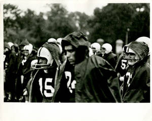 Springfield College Football players on sideline in rain, 1965