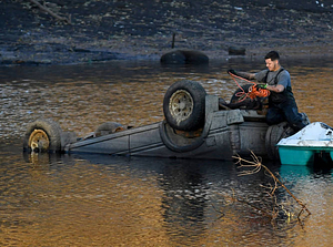 A workman preparing a vehicle to be removed from Lake Massasoit (2020)