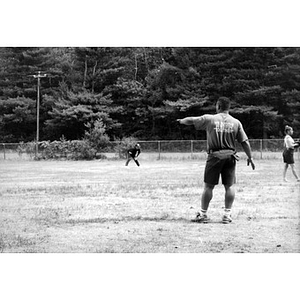 Inquilinos Boricuas en Acción staff playing baseball on a grassy field.