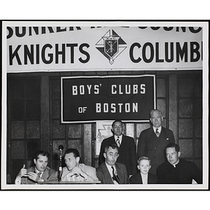 An award winner posing with several officers and guests during an awards event held by the Boys' Clubs of Boston and the Knights of Columbus Bunker Hill Council