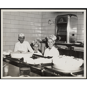 Two members of the Tom Pappas Chefs' Club pose with a cook in the Hanscom Field Air Force Base restaurant kitchen