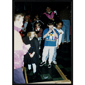 Children in costumes play a game at a Halloween party