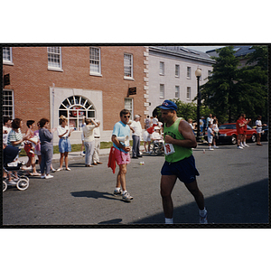 Spectators line the course of the Bunker Hill Road Race as a runner passes by